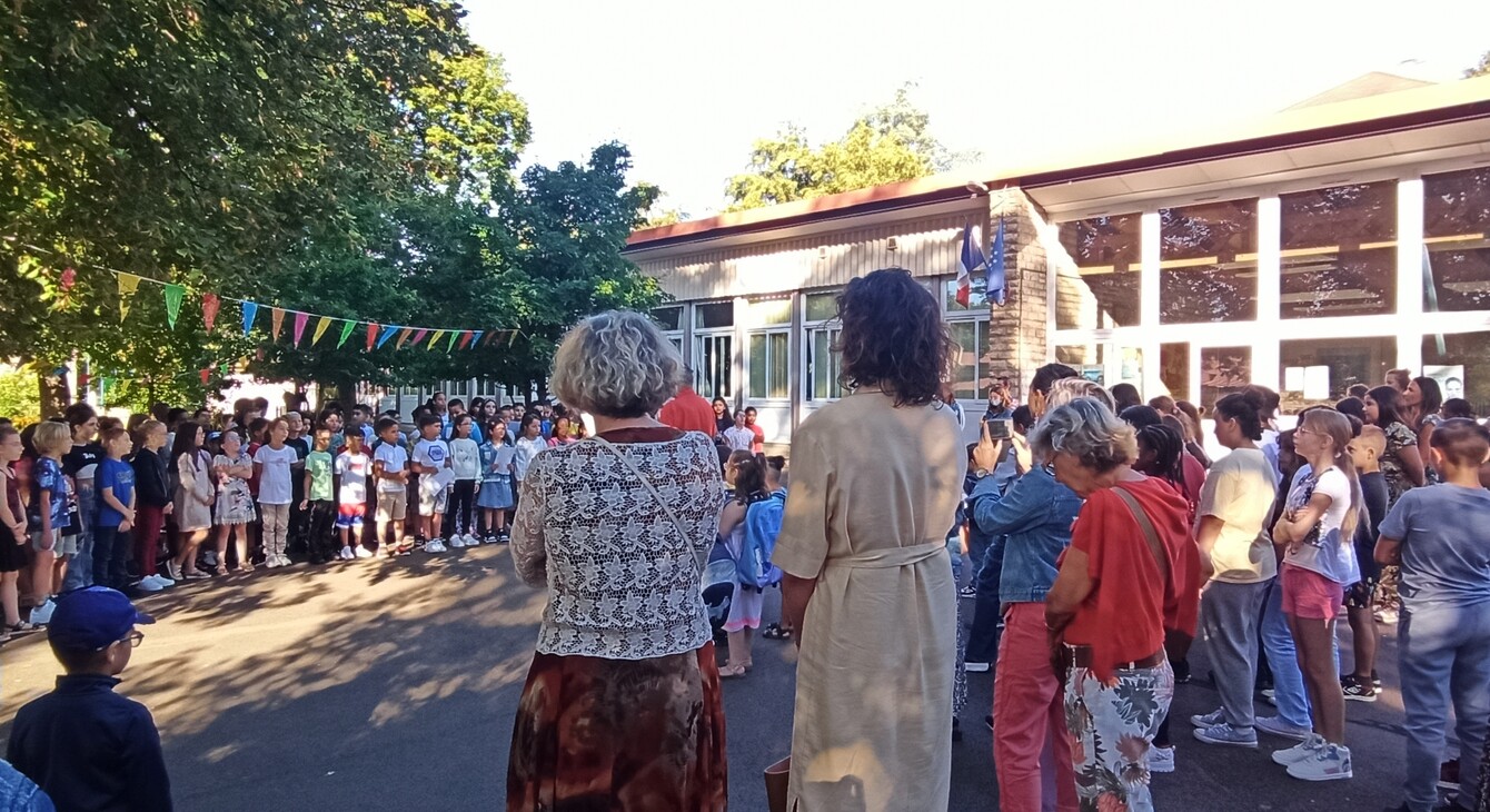 Madame Ménissier (IA-DASEN) et Madame Merlet (IEN du Creusot) regardent les enfants de l'école Marie Curie du Creusot chanter