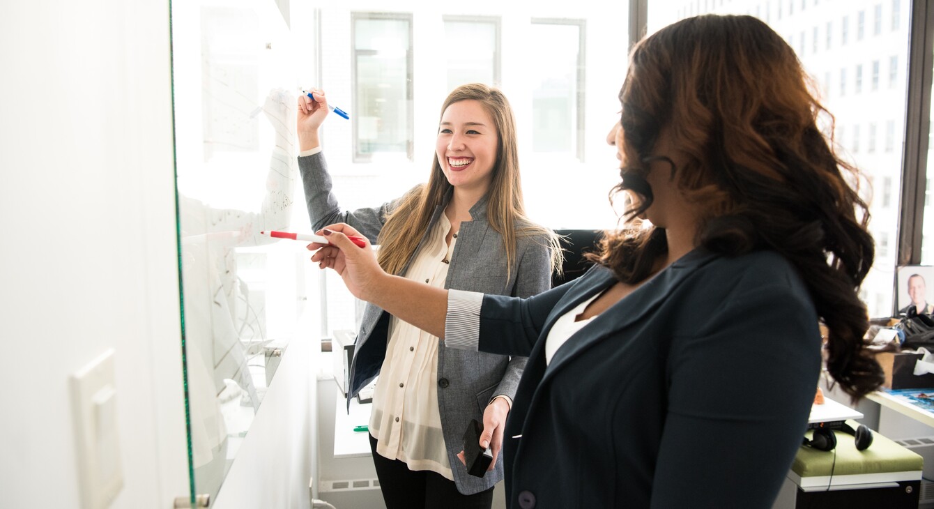 Deux femmes devant un tableau blanc