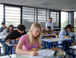 Une classe passe les épreuves écrites du bac, avec une jeune fille au premier plan.