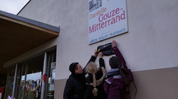 Une élève et des enseignantes s'apprêtent à retirer le cache de la plaque "Ecole bilingue"