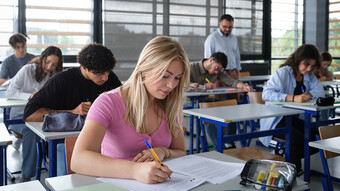 Une classe passe les épreuves écrites du bac, avec une jeune fille au premier plan.