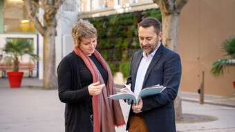 Deux personnels discutent dans une cour d'établissement