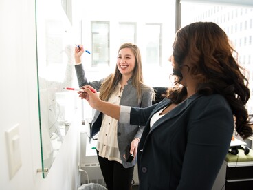 Deux femmes devant un tableau blanc