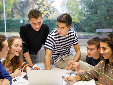 groupe de lycéens discutant autour d'un ordinateur